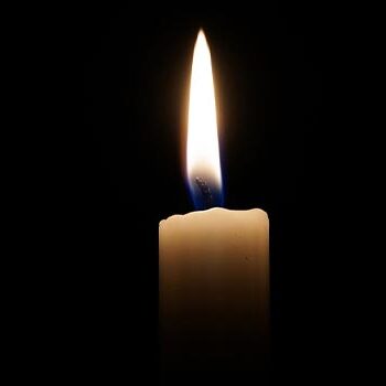 A single candle lit in a dark room