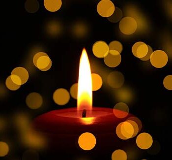 Lit candle in dark room