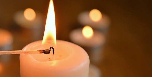 Tea candle being lit by a match