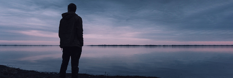 Man staring out into the sea in the evening