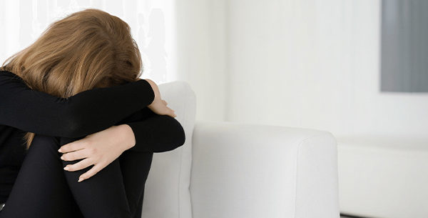 Person in grief on white couch