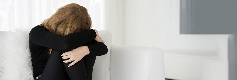 Person in grief on white couch