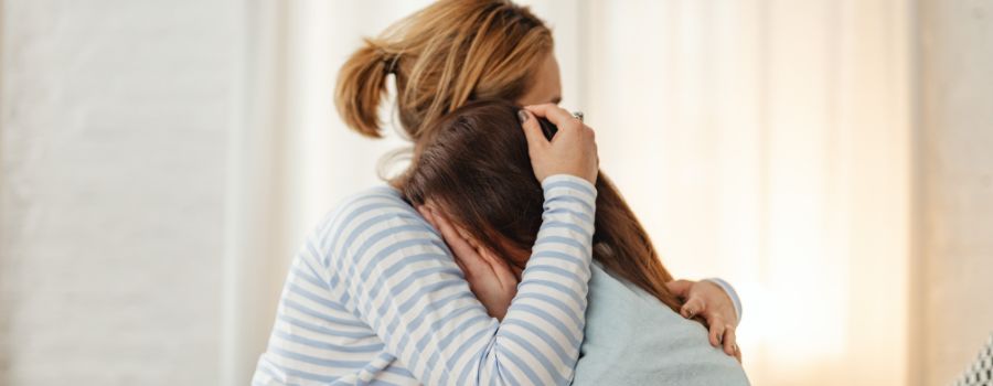 a woman comforting another woman