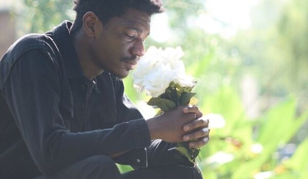 man grieving at gravesite